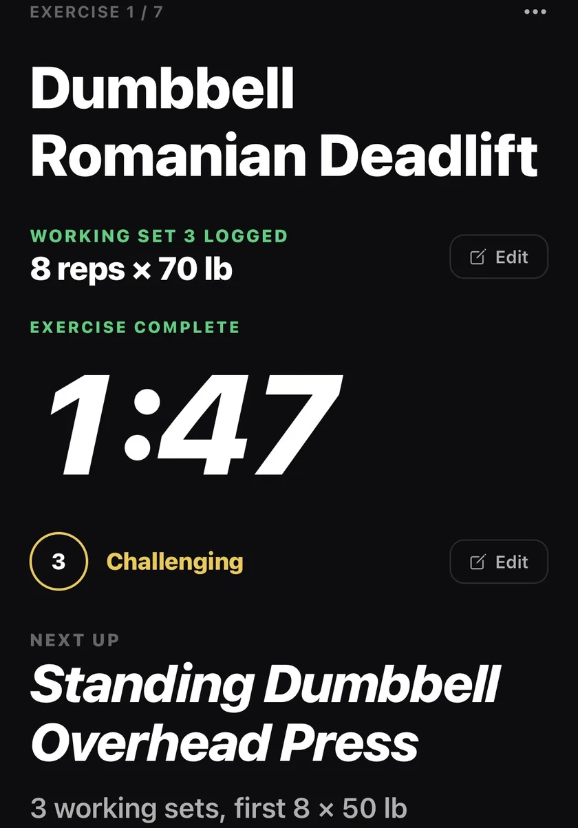 Working set 3 logged, rest timer at 1:47, and Standing Dumbbell Overhead Press queued next